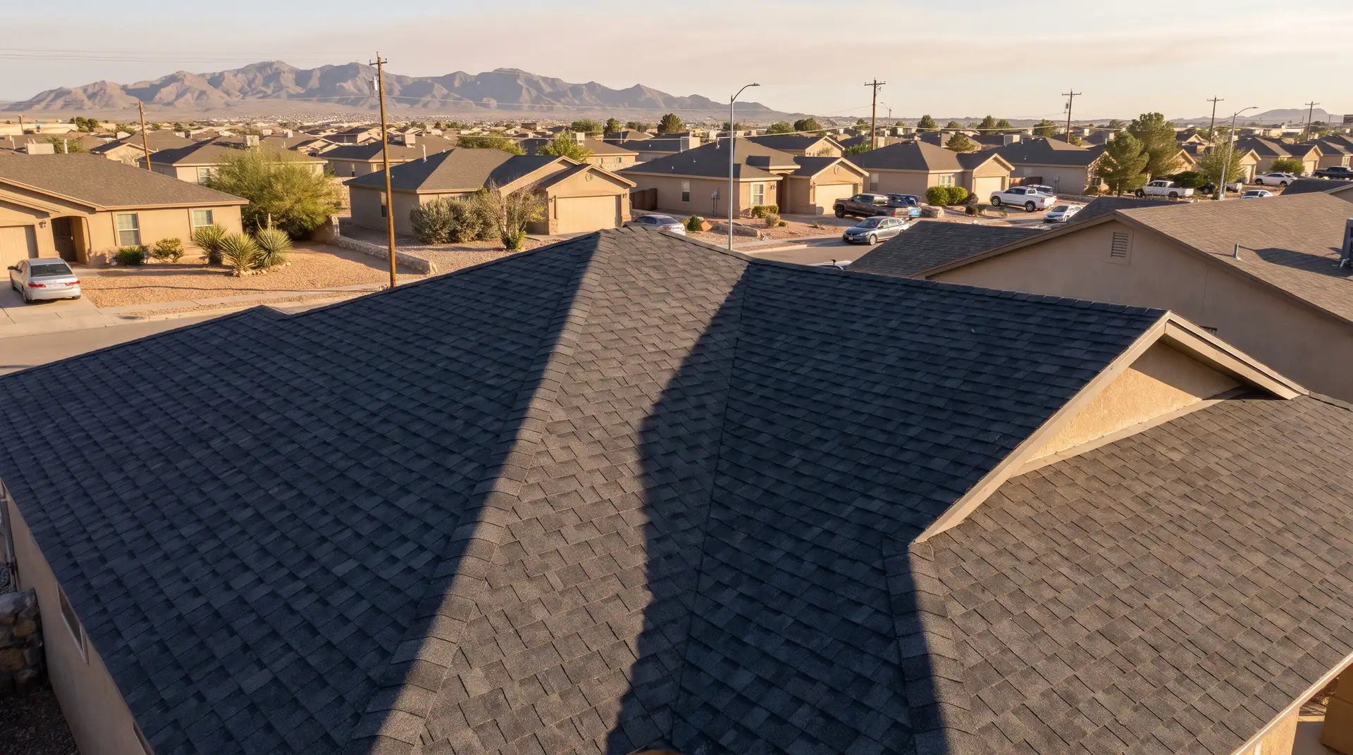 Dark shingle roofs on a desert subdivision in late sun
