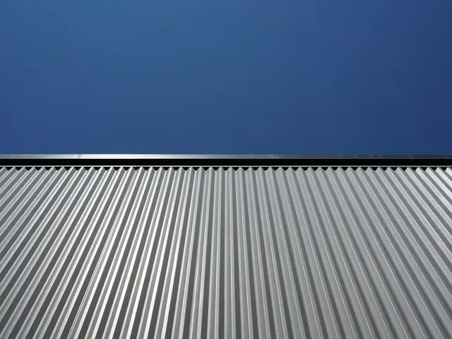 Close view of ribbed metal roof panels against a blue sky